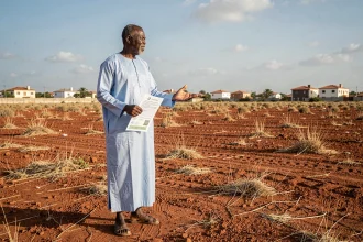 Homme sénégalais tenant un titre foncier sur un terrain à vendre près de Dakar au Sénégal